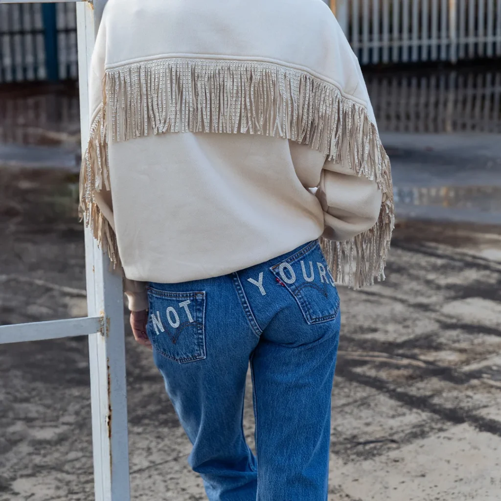 outfit sporty chic con jeans Levi's personalizzati e felpa con frange